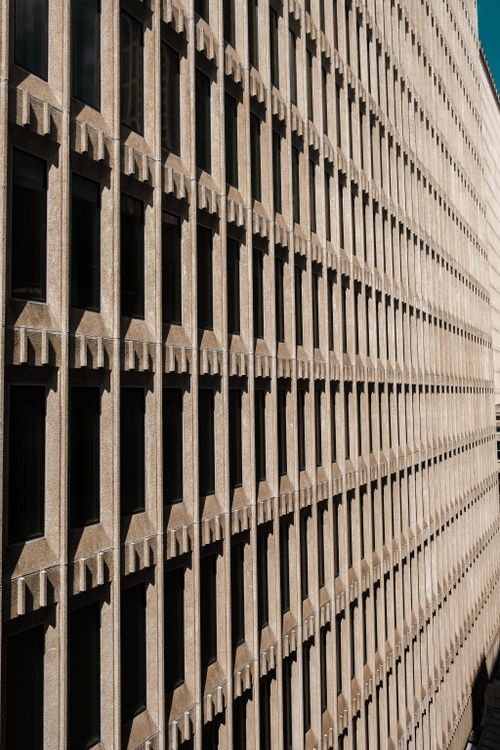 Free Geometric concrete facade with repeating window patterns showcasing urban architecture and symmetry. Stock Photo
