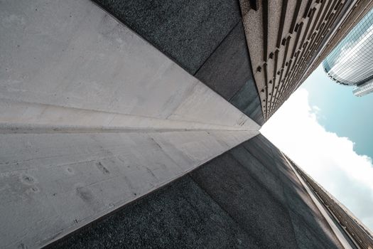 Striking low-angle view of modern skyscrapers with concrete facades against a clear sky.
