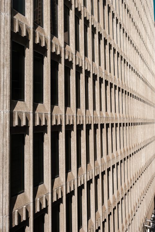 Free A detailed view of a modern building facade with repeating patterns and shadows. Stock Photo