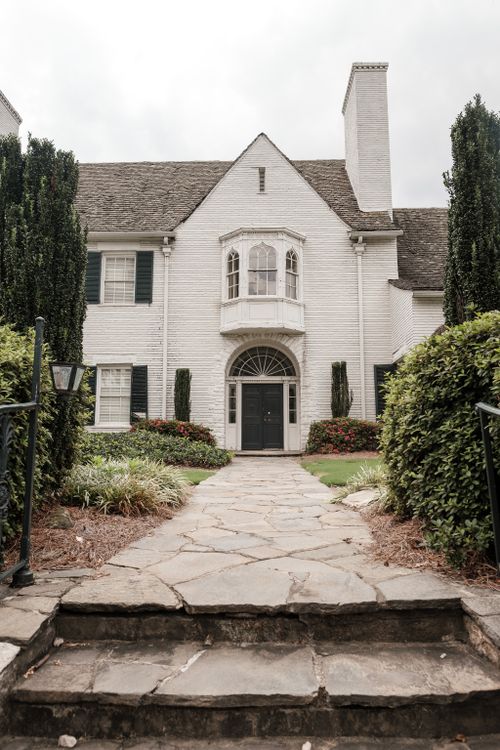 Free Elegant white brick house with arched doorway and landscaped garden. Stock Photo