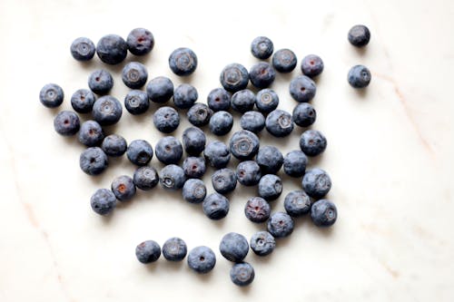 Free Photo of Black Berries on White Surface Stock Photo