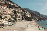 在晴朗的天空下，意大利阿马尔菲海岸呈现出一片充满活力的海滩全景