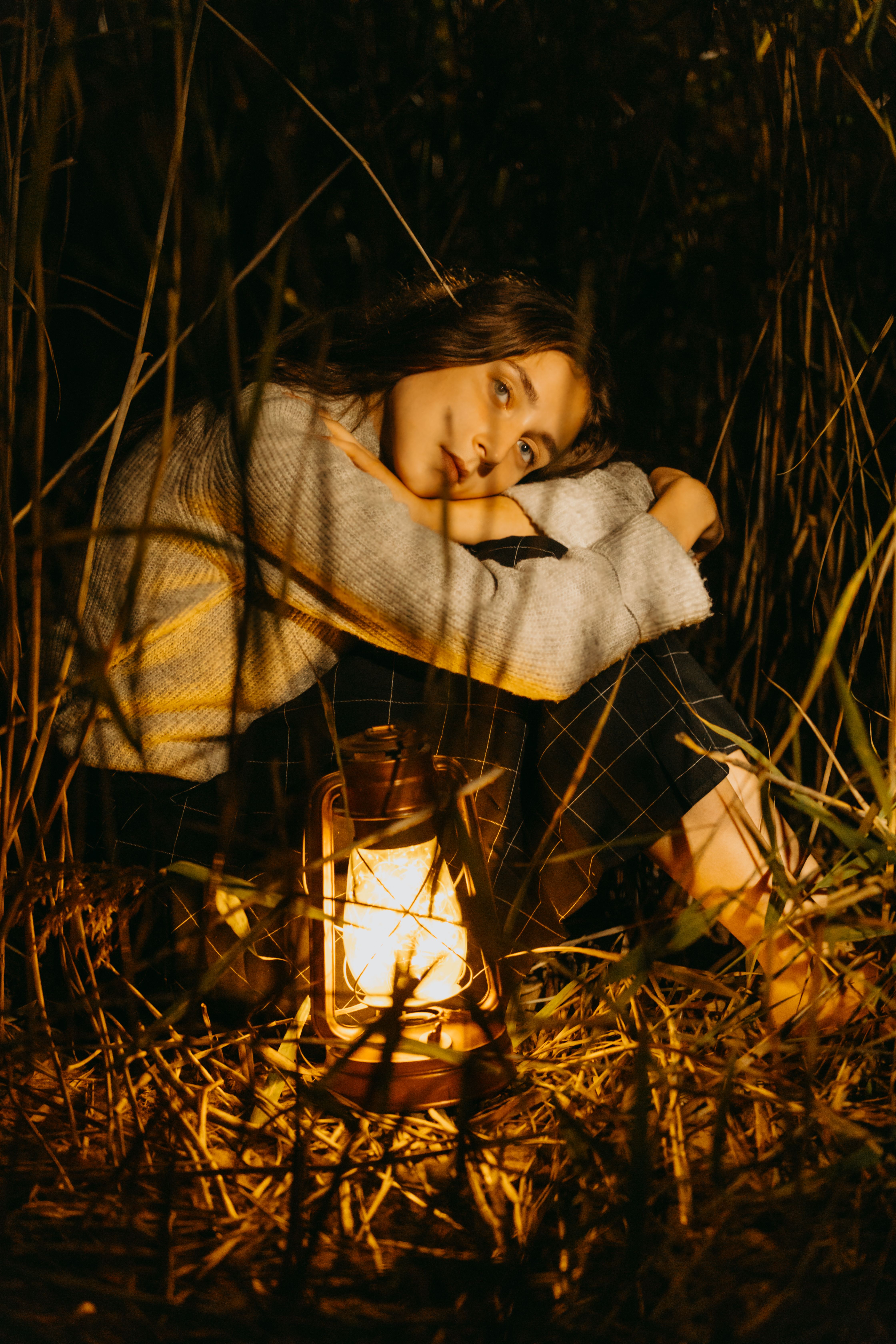 Woman in Gray Knit Sweater Sitting Beside the Lantern · Free Stock Photo