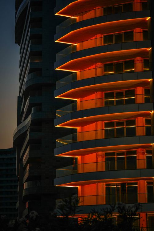 Free A striking modern building illuminated by vibrant neon lights at dusk. Stock Photo