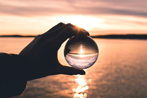 Free Photo Displays Person Holding Ball With Reflection of Horizon Stock Photo