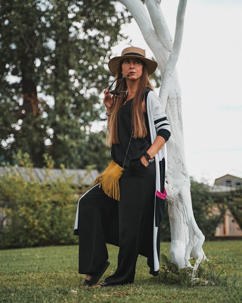 Woman in a Black Jumpsuit Posing with Her Hand in Her Pocket