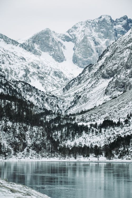 Free Scenic winter view of Gaube Lake and snow-capped Pyrenees in Cauterets, France. Stock Photo