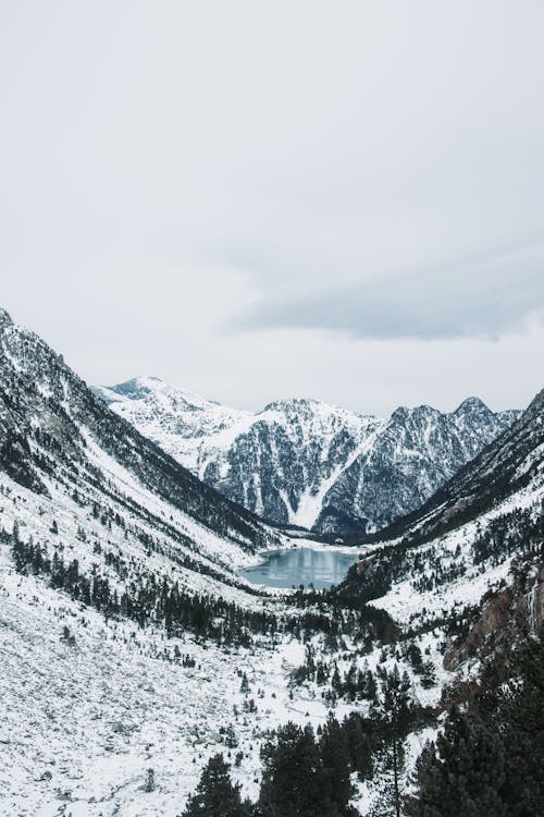 Body of Water Among Snow Covered Mountains