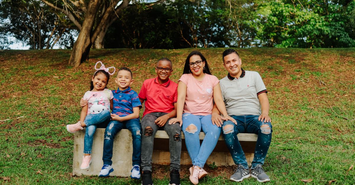 Joyful family enjoying outdoor time on a park bench with smiles and love.