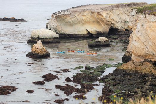 Kayakers exploring the scenic cliffs and rock formations at Pismo Beach, California.