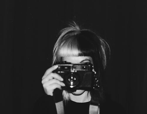 Grayscale Photo of Woman Holding Camera
