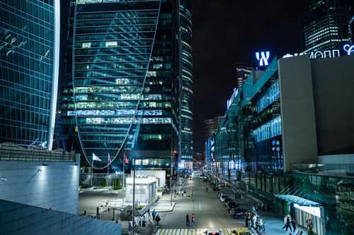 Free Vibrant city scene at night with glass skyscrapers and busy streets, capturing urban energy. Stock Photo