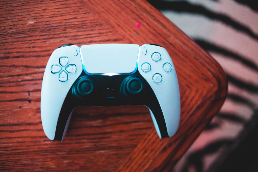 Close-up white game controller on wooden table