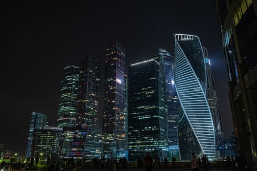 Majestic night skyline of Moscow with illuminated skyscrapers and vibrant urban atmosphere.
