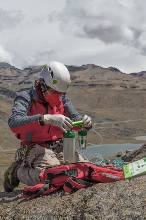 A Man in a Face Mask Looking at an Oxygen Regulator