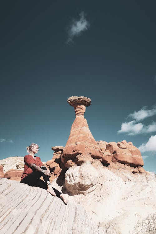 Free Woman Sitting beside Rock Formation  Stock Photo
