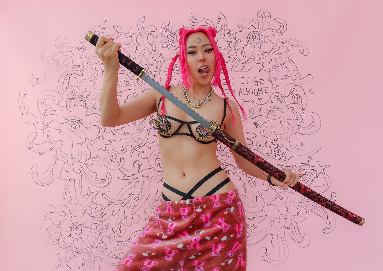 creative cosplay portrait featuring a woman with pink hair posing with