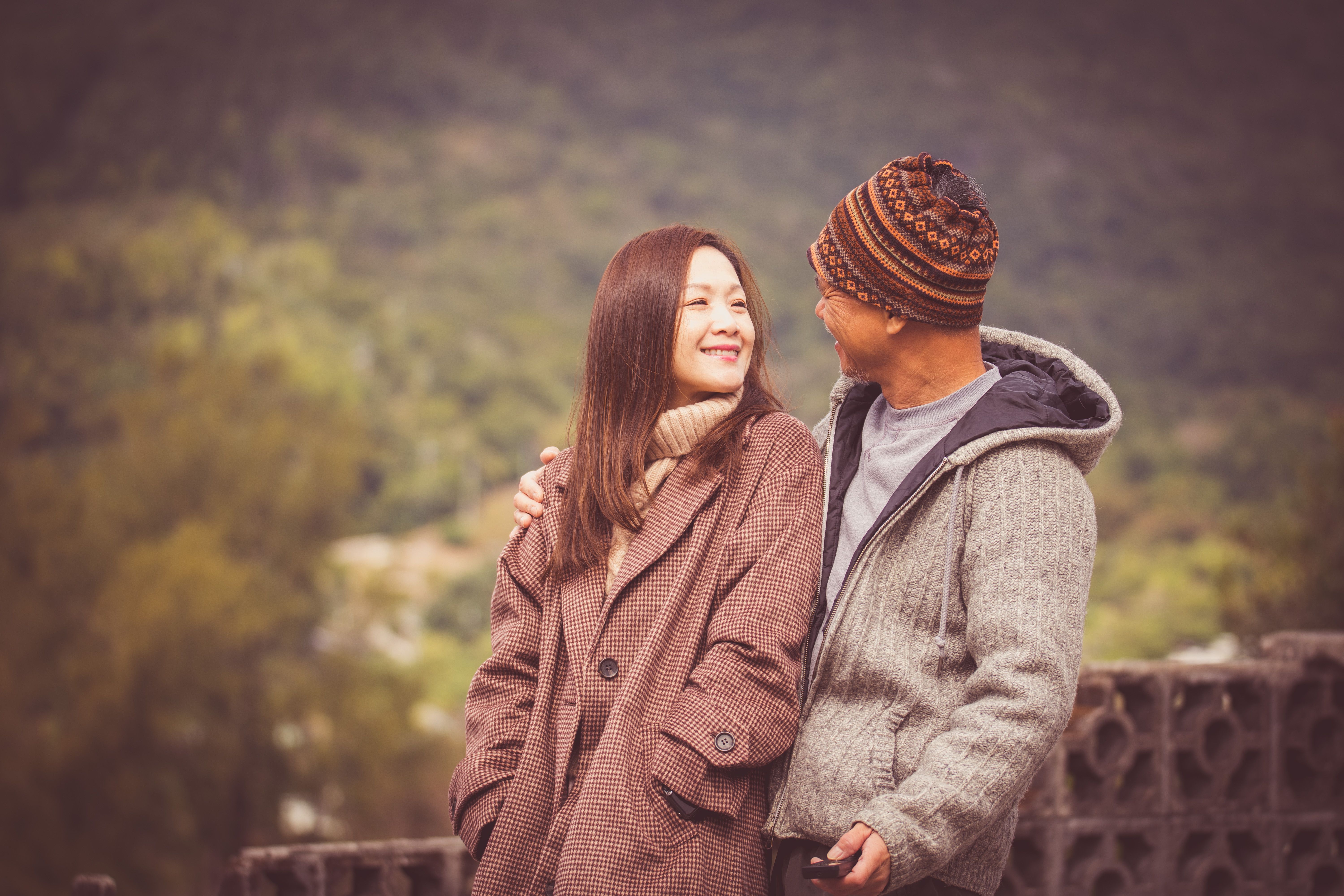 A couple in warm clothing sharing a moment outdoors during fall in Hong Kong.
