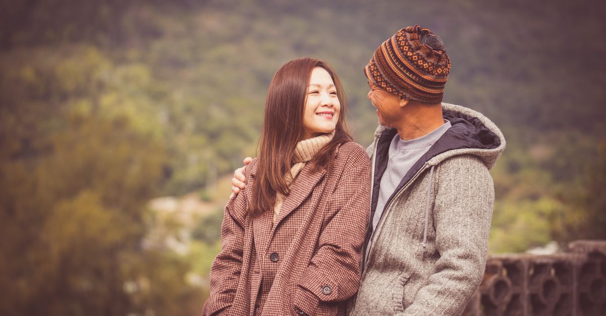 A couple in warm clothing sharing a moment outdoors during fall in Hong Kong.