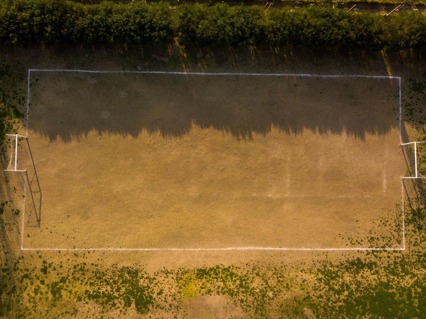 Drone shot of an empty soccer field in Buenos Aires showing light and shadow play.