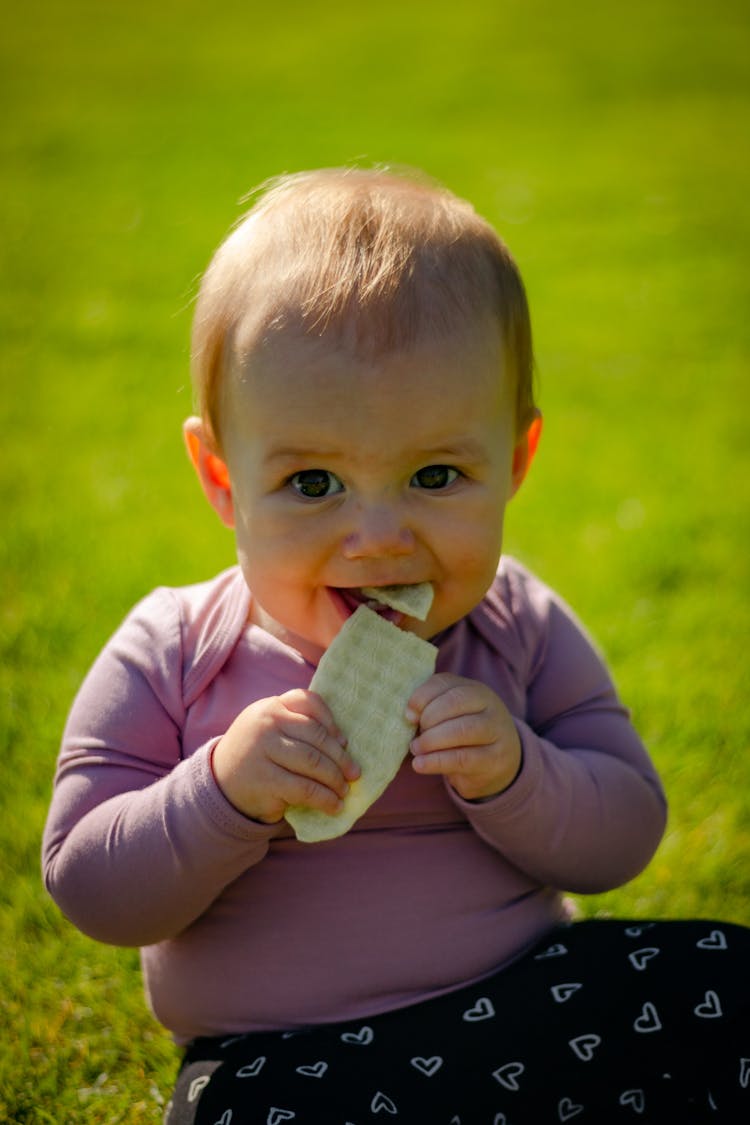 A Baby Smiling While Eating A Food