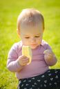 Baby in Pink Long Sleeve Shirt Sitting on Green Grass Field