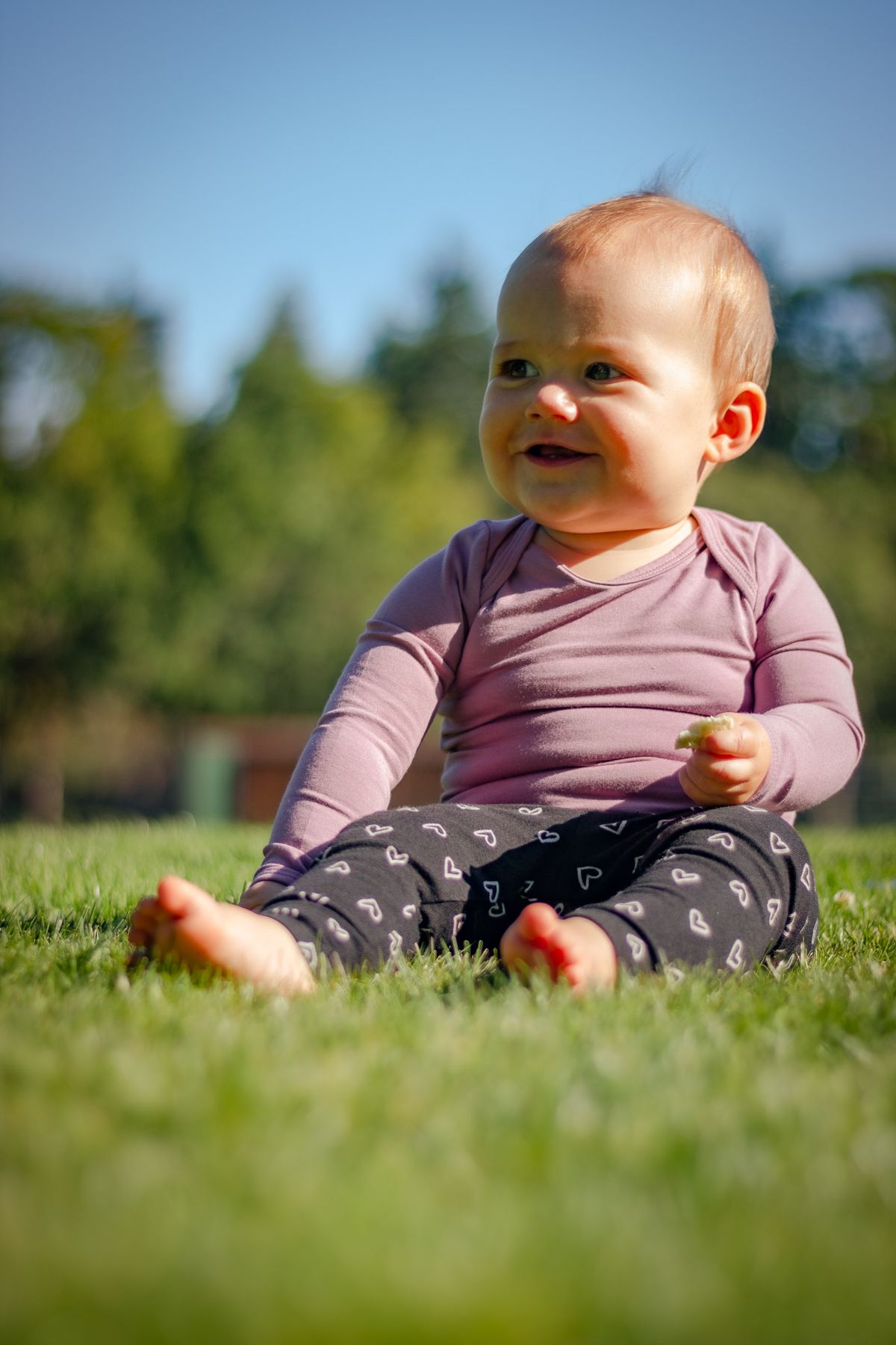 Baby sitting on grass outdoors for first birthday photoshoot ideas