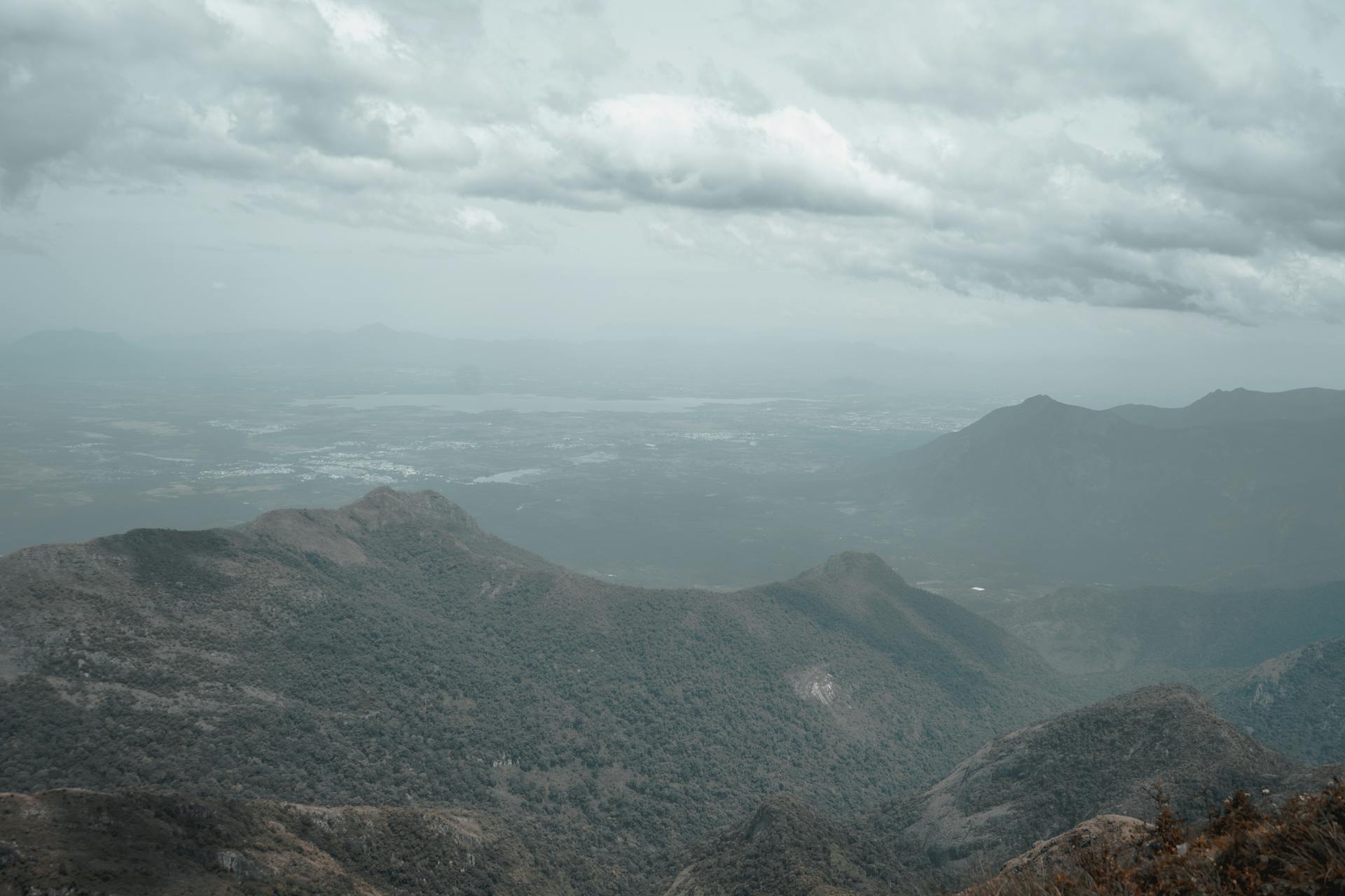 Foggy mountain landscape in Ooty, Tamil Nadu with cloudy skies and lush nature.