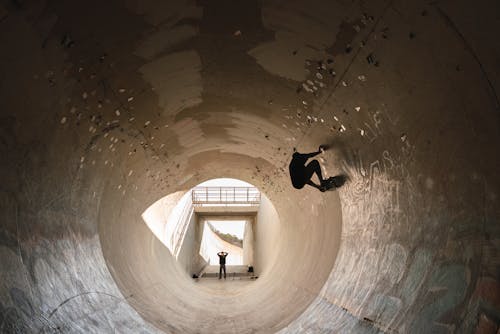 Man in Black Jacket and Pants Standing on Tunnel