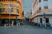 热闹的城市街道上设有咖啡馆、标牌和停放的摩托车，展现了理想的城市生活方式主题