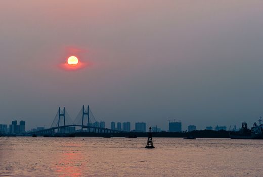 城市天际线的斜拉桥上，日落美景映衬在背景中