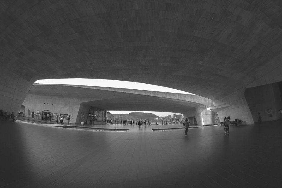 A black and white tunnel scene showcasing modern architecture with people walking.