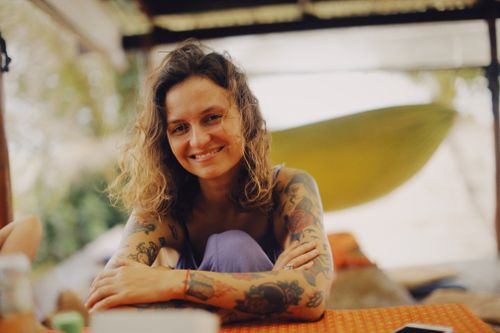 Free A joyful young woman with tattoos enjoying a relaxing day outdoors, exuding happiness and warmth. Stock Photo