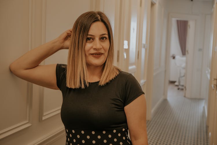 Woman Wearing Polka Dot Dress Shirt Standing On Doorway