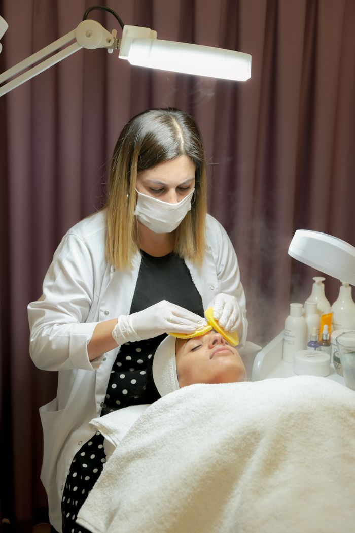 Beautician performing a facial treatment in salon