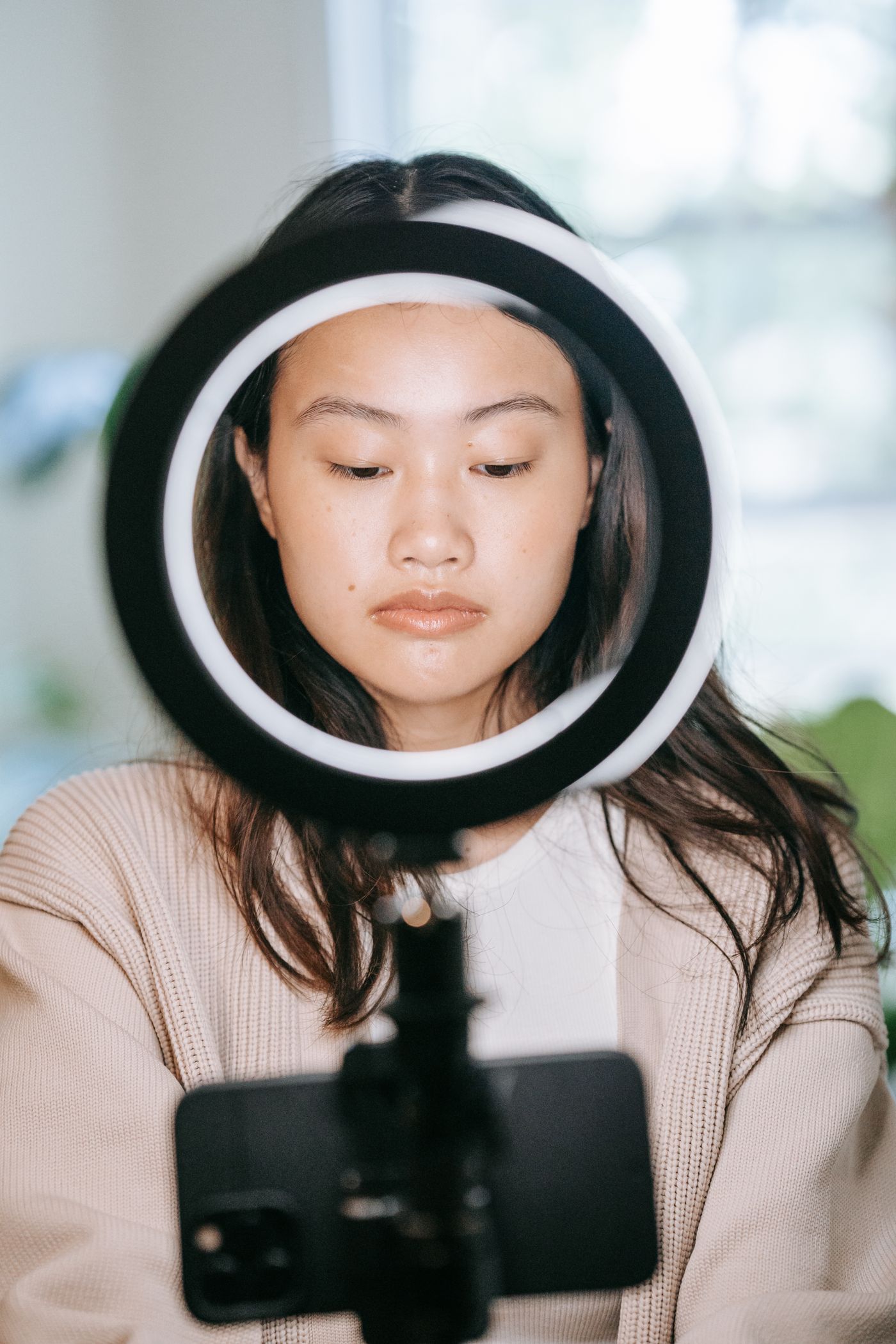 Creator recording video through a ring light with a smartphone
