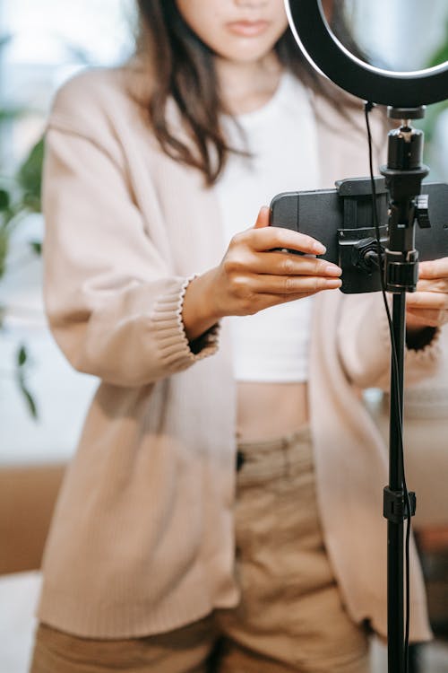 Woman Setting Up a Phone in a Tripod