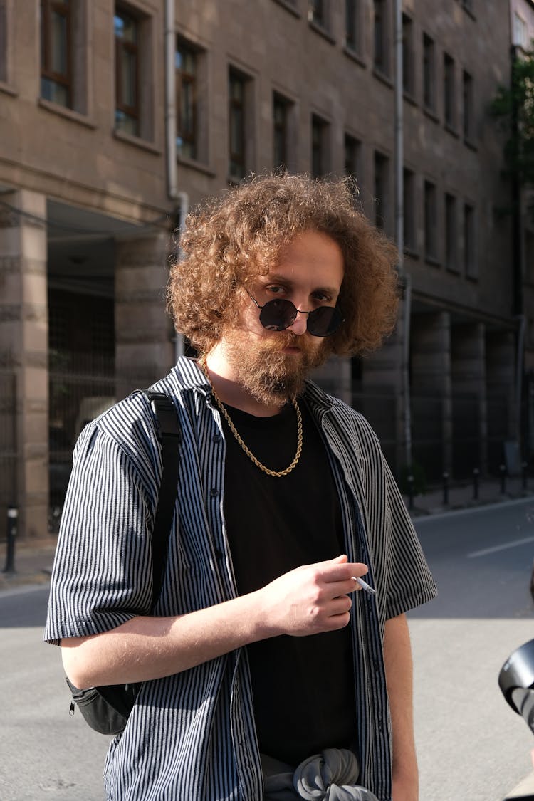 Man In Black And White Striped Polo Shirt Wearing Black Sunglasses