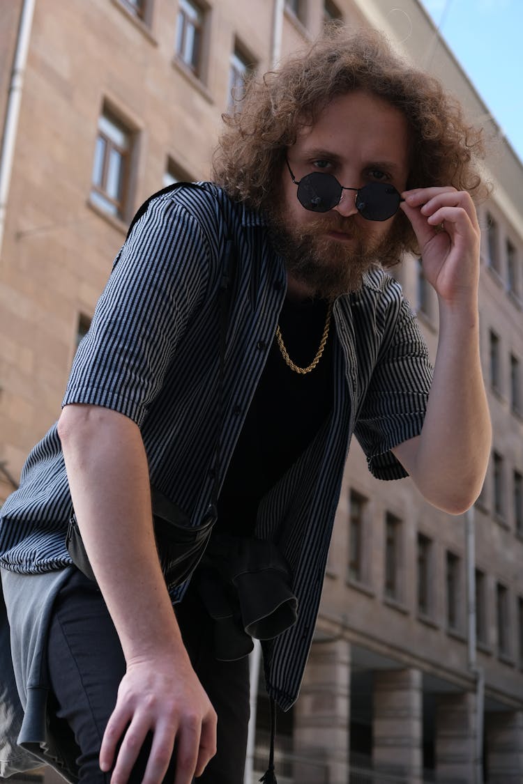 Low Angle Shot Of A Man In Black And White Striped Shirt Wearing Black Sunglasses