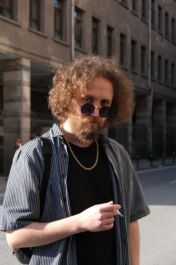 Man In Black And White Striped Polo Shirt Holding Cigarette