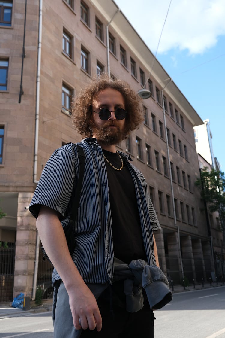 Man Wearing Black Sunglasses Standing In Front Of A Building