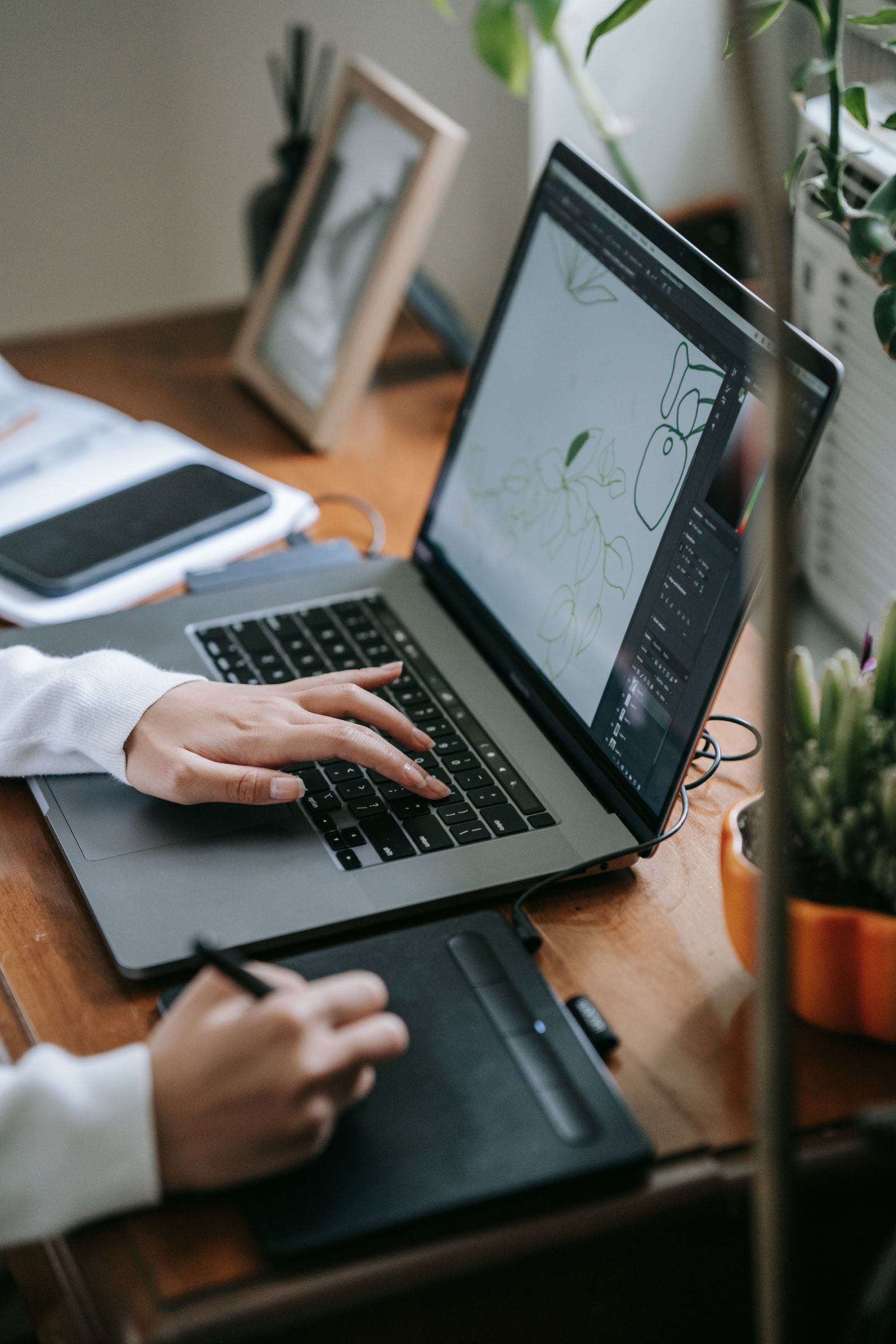 A digital artist working with a laptop and drawing tablet
