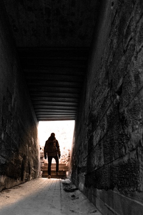 Free Silhouetted man in a tunnel, bathed in sunlight, creating a dramatic, moody effect. Stock Photo