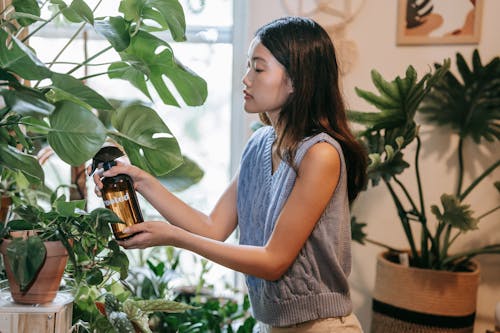 Woman in Knitted Top Holding a Brown Spray Bottle