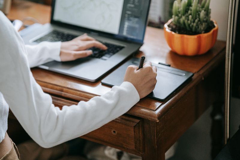 Designer reviewing a 3D garment sketch on a graphics tablet