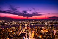 在戏剧性的日落天空下，令人惊叹的纽约市天际线鸟瞰图与充满活力的灯光交相辉映