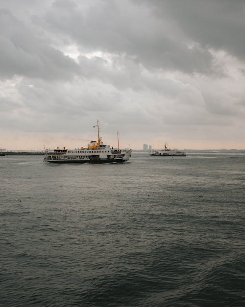 Free White and Black Ship on Sea Under Gloomy Sky Stock Photo
