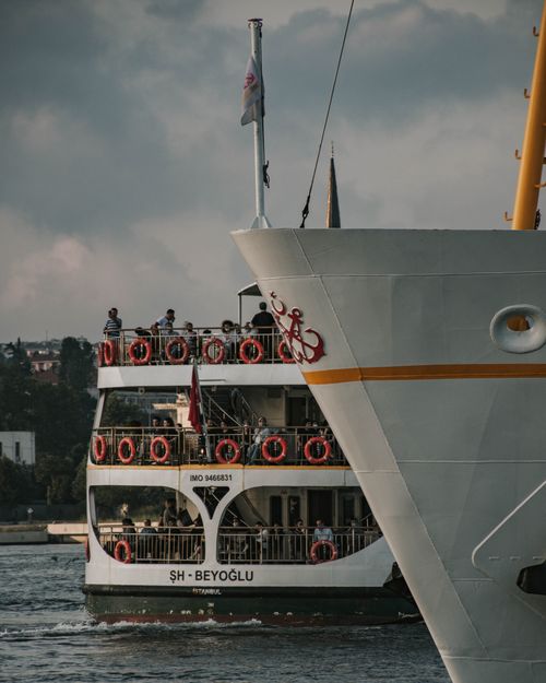 Free A bustling harbor scene with a large ferry and people on deck, emphasizing maritime travel. Stock Photo