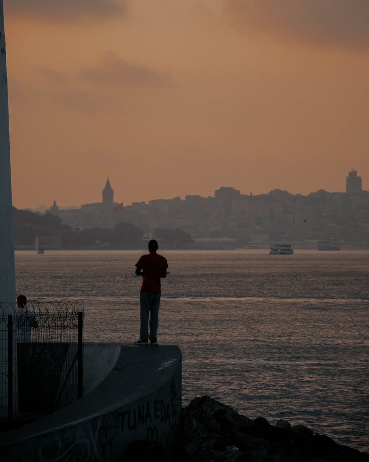 Man Standing On Sea Shore In Istanbul At Sunset