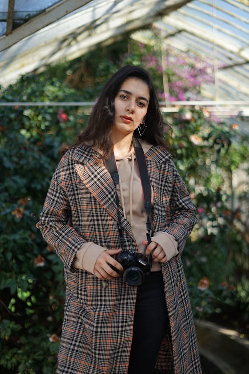 Woman in Plaid Coat Holding a Camera